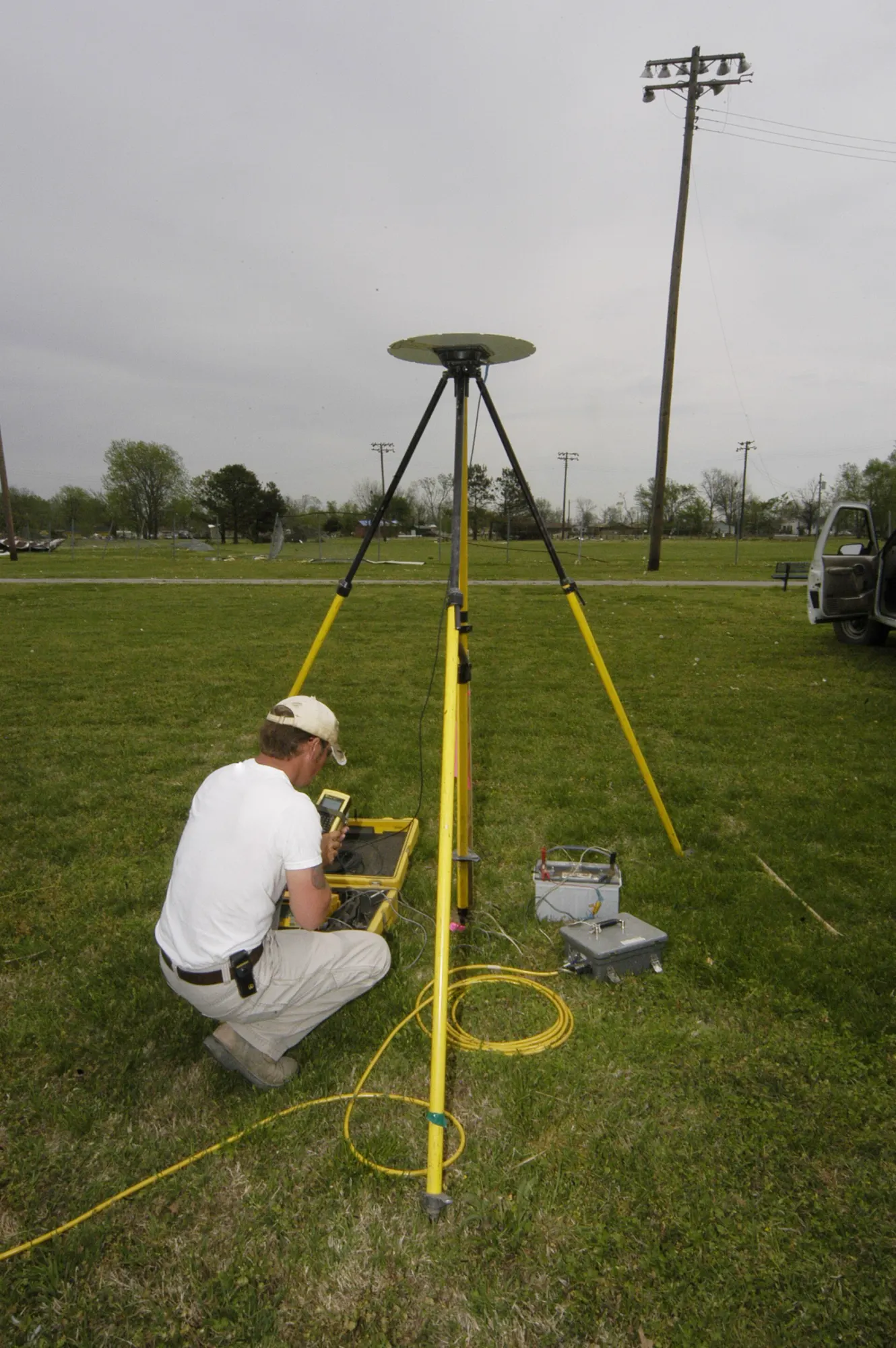 Surveyor working at a robotic total station in a field