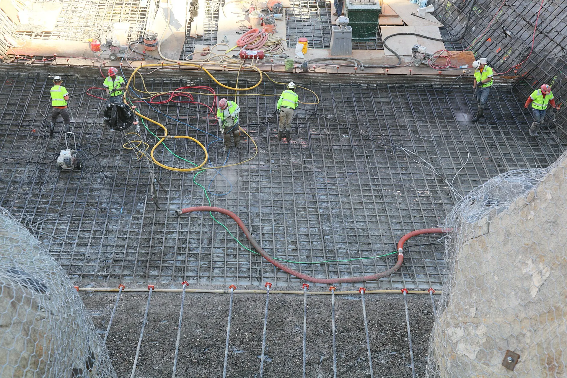 A construction crew working across a large rebar foundation
