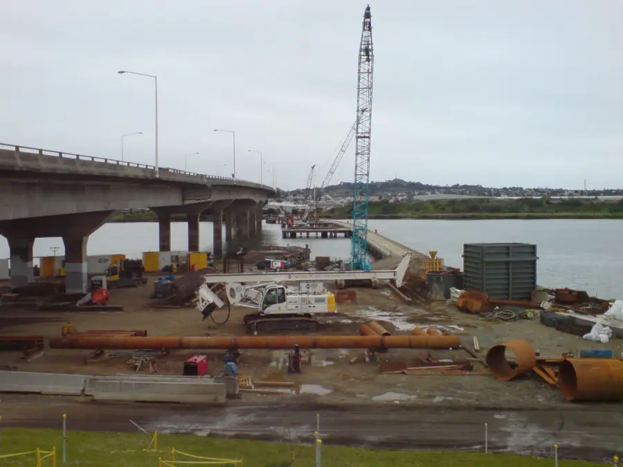Barges and cranes building a river crossing.