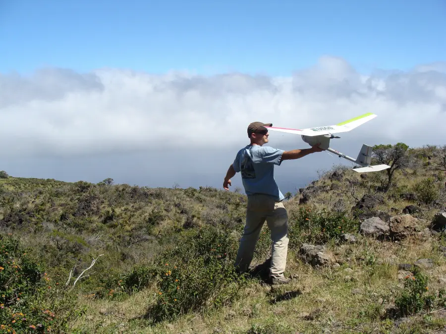 A fixed-wing mapping drone launched from a ridge.