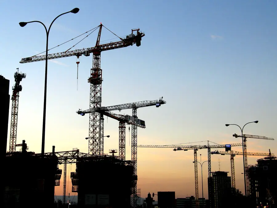 Tower cranes against the early-morning sky.